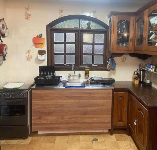 a kitchen with a sink and a stove at Casa Aconchegante em Monte Verde in Camanducaia