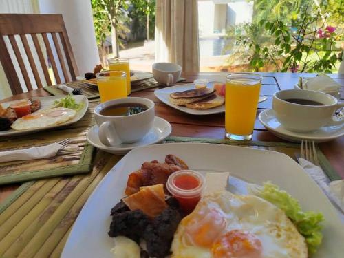 a table with a plate of breakfast food and drinks at Casa Guadalupe in Sipacate