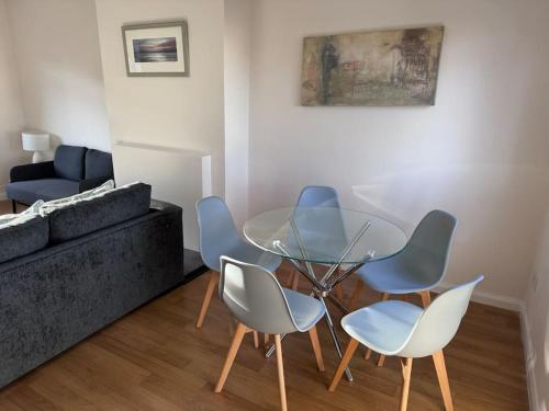 a living room with a glass table and chairs at 4 Bed House, Glenrothes sleeps 5 in Fife