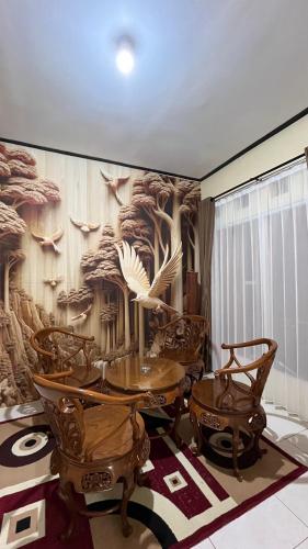 a dining room with a wall with a bird mural at Villa Kolah Watu in Wonosobo