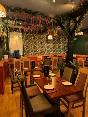 a restaurant with wooden tables and chairs and flowers at The Old Court Hotel in Witney