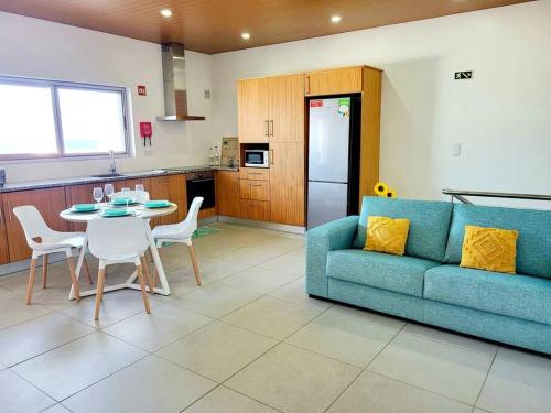 a living room with a blue couch and a table at A Casa da Concha in Rabo de Peixe