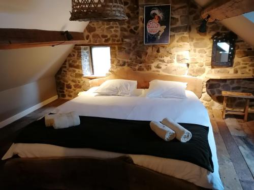 een slaapkamer met een groot bed in een stenen kamer bij Maison de gesves in Gesves