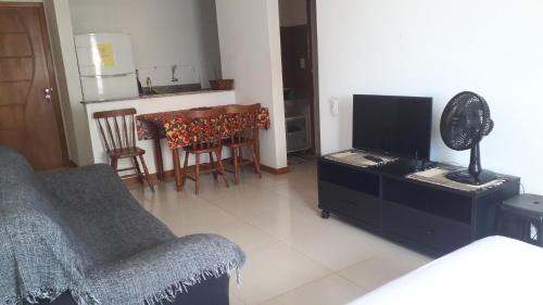a living room with a couch and a table with a television at Privileg in Ilhéus