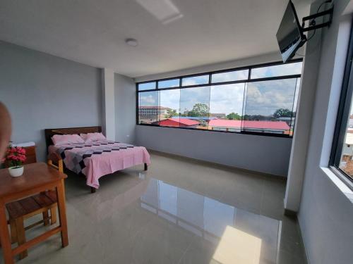 a bedroom with a bed and a large window at Casa Alojamiento Picuro Lodgind in Iquitos