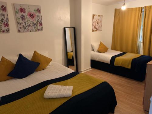 a room with two beds and a mirror at London Stratford 4 Bedrooms Apartment in London