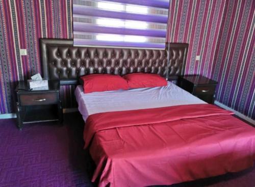 a bedroom with a large bed with red pillows at Emma Luxury Camp in Wadi Rum