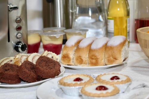 a table with three plates of pastries and other desserts at Johal Mini Hotel -Birmingham City-FREE BREAKFAST in Birmingham