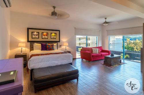 a bedroom with a bed and a red chair at Antigua de Cabo in Cabo San Lucas
