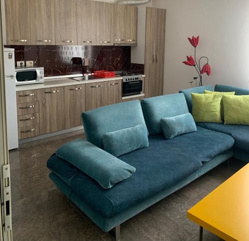 ein Wohnzimmer mit einer blauen Couch in einer Küche in der Unterkunft Quartz Apartament in Durrës