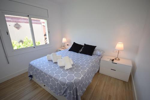 a bedroom with a bed with two pillows and a window at Castelldefels Playa in Castelldefels