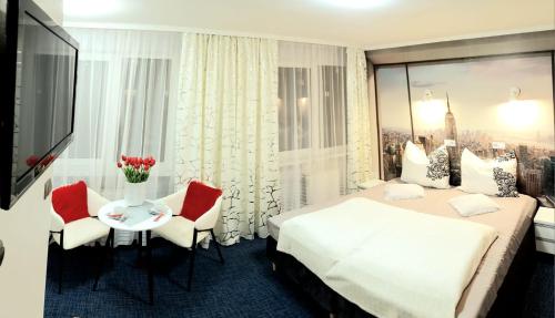 una camera d'albergo con letto, tavolo e sedie di HORTENSJA 304 a Koszalin