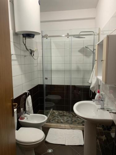 ein Bad mit einer Dusche, einem WC und einem Waschbecken in der Unterkunft Quartz Apartament in Durrës