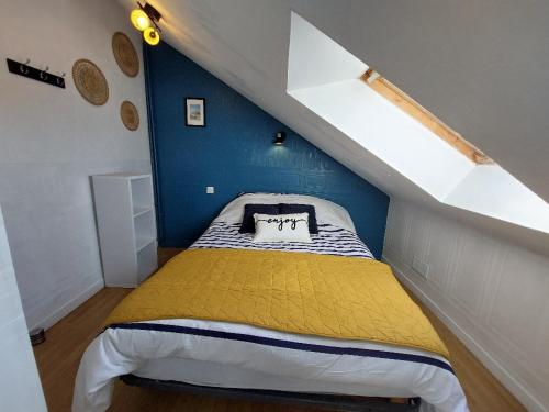 a bedroom with a yellow bed with a blue wall at Gîte du moulin Mont Saint Michel in Pontorson