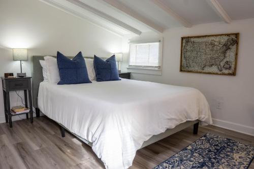 um quarto com uma grande cama branca com almofadas azuis em Carriage on Capital near Distilleries & Downtown em Frankfort