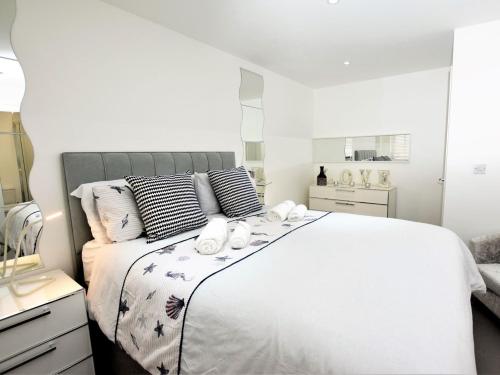 a bedroom with a large white bed with towels on it at 3 bed property in Ferryside 53442 in Ferryside