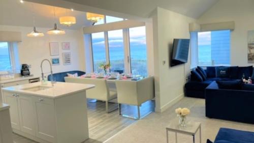 a kitchen and living room with a table and a couch at Harbour Sands - 4 Bed With Stunning Coastal Views in Amble