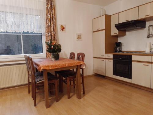 una cocina con una mesa de madera con sillas y una ventana en Fuchs, en Eslohe