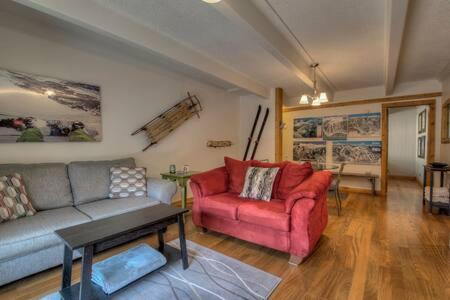 a living room with a couch and a red chair at Ski Breck Condo Clubhouse and Free Breck Shuttle in Breckenridge