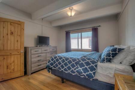 a bedroom with a bed and a television and a dresser at Ski Breck Condo Clubhouse and Free Breck Shuttle in Breckenridge