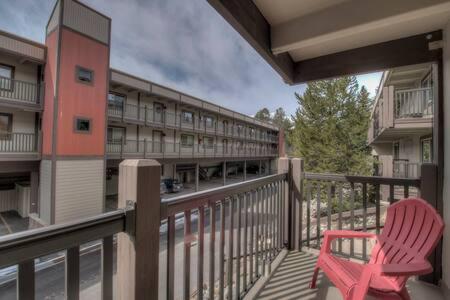a red chair sitting on a balcony of a building at Ski Breck Condo Clubhouse and Free Breck Shuttle in Breckenridge