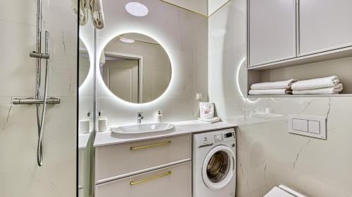 a bathroom with a sink and a washing machine at Rezydencja Niechorze 304 przy Plaży - 5D Apartamenty in Niechorze