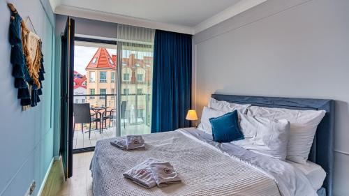 um quarto com uma cama com toalhas em Rezydencja Niechorze 304 przy Plaży - 5D Apartamenty em Niechorze
