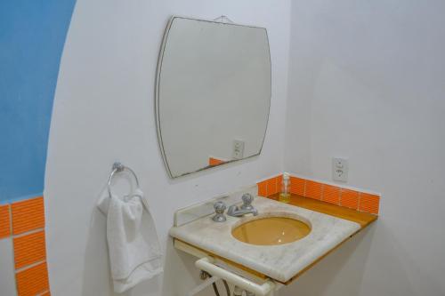 a bathroom with a sink and a mirror at Verde Vida Ecopousada - Termas do Gravatal in Gravatal