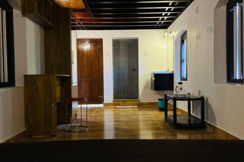 a room with a table and a television in it at Aadhya Homestay 4BHK in Wayanad