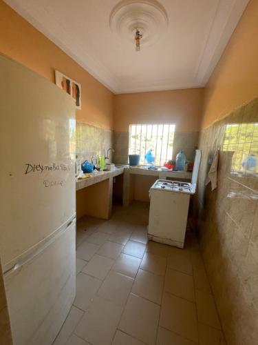 a kitchen with a sink and a refrigerator at Grand Yoff in Ziguinchor