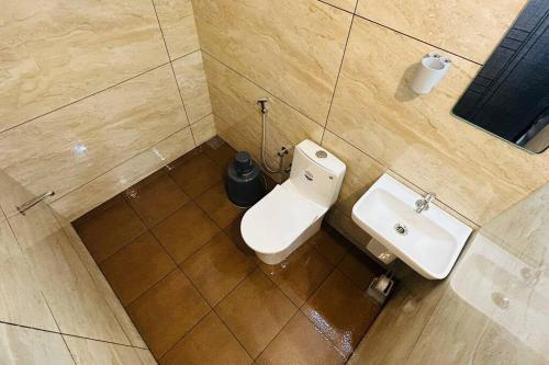 a bathroom with a toilet and a sink at Aadhya Homestay 4BHK in Wayanad