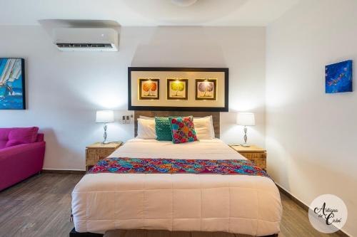 a bedroom with a large bed and a purple couch at Antigua de Cabo in Cabo San Lucas