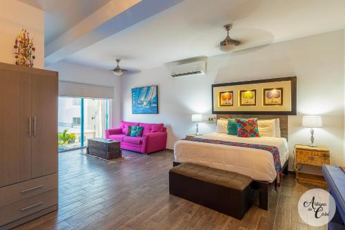 a bedroom with a bed and a pink couch at Antigua de Cabo in Cabo San Lucas