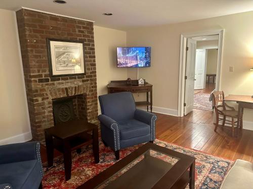 - un salon avec une chaise et une cheminée dans l'établissement Fully furnished garden apartment, à Savannah