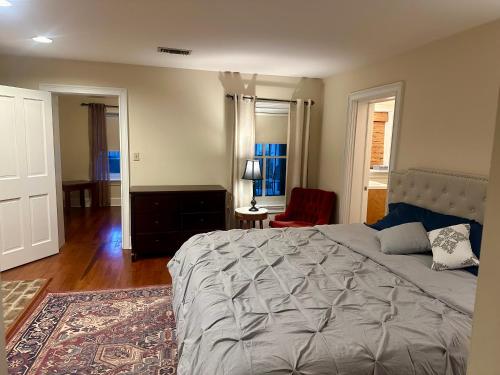 - une chambre avec un grand lit et une chaise rouge dans l'établissement Fully furnished garden apartment, à Savannah