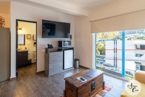 a living room with a large window and a tv at Antigua de Cabo in Cabo San Lucas