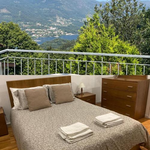 a bedroom with a bed with towels on it at Casa de Casarelhos - Vistas rio - "Gerês" in Geres