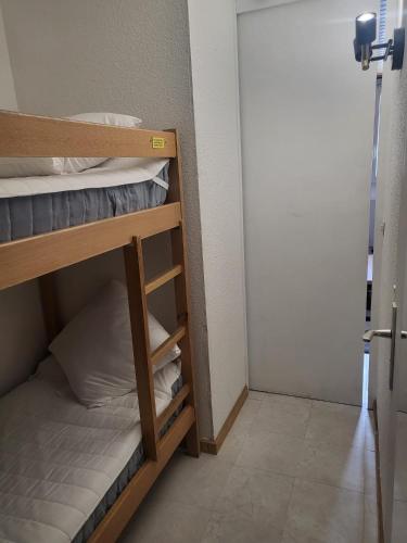Cette petite chambre comprend des lits superposés et une porte. dans l'établissement Appartement 4 personnes ski aux pieds, à Les Deux Alpes