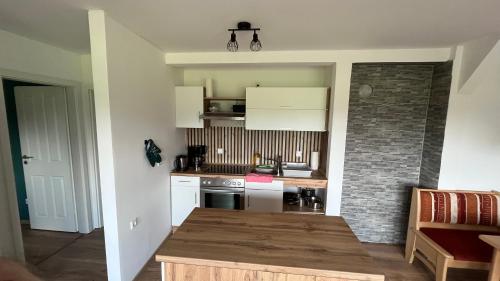 a kitchen with white appliances and a brick wall at Allgäuhaus Thomas am Bauernhof Ferienwohnung in Wald