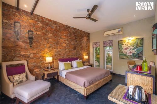 1 dormitorio con cama y pared de piedra en StayVista at Poetry by Rawai - Pushkar, en Pushkar