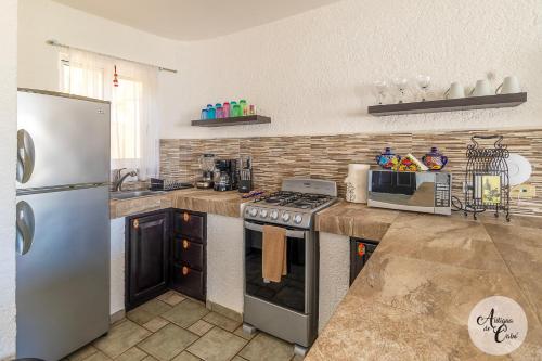 a kitchen with a stove and a refrigerator at Antigua de Cabo in Cabo San Lucas