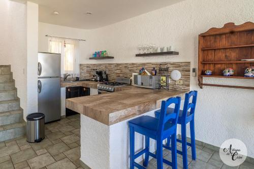 a kitchen with a counter and two blue stools at Antigua de Cabo in Cabo San Lucas