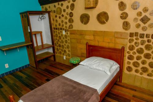 a bedroom with a bed in a room with stone walls at Verde Vida Ecopousada - Termas do Gravatal in Gravatal