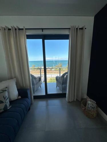 a living room with a couch and a view of the ocean at Ocean View Villa - Upper in St Helena Bay