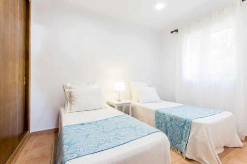 2 letti in una piccola camera con pareti bianche di Villa Anita a Santo Tomás
