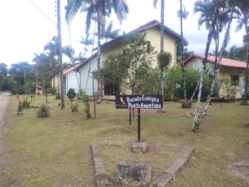 un panneau dans une cour devant une maison dans l'établissement Pousada Porto Aventura -Chalés da Luci, à Peruíbe