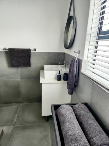 a bathroom with a sink and a mirror at Ocean View Villa - Upper in St Helena Bay