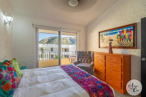 a bedroom with a bed and a dresser and a window at Antigua de Cabo in Cabo San Lucas