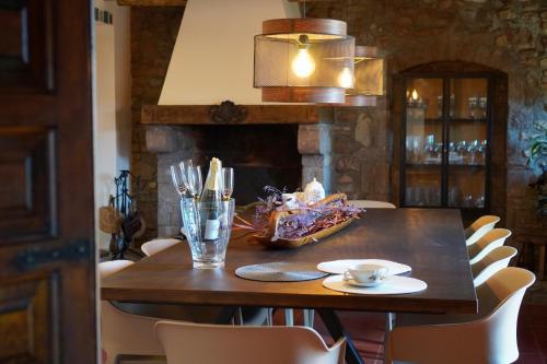 mesa de comedor con sillas y chimenea en L'Hostatgeria, en Estany