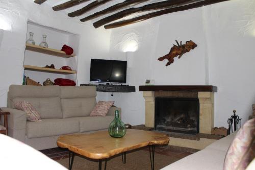 sala de estar con sofá y chimenea en Cortijo Wenceslao II, 